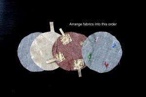 Sandwich the fabrics in this order: embroidered thin fabric on top, then thick circle, then conductive fabric circle and then the other thin fabric circle on the bottom